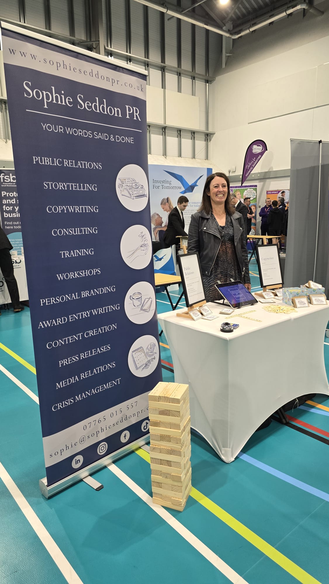 Sophie Seddon PR at the Mid Yorkshire Chamber of Commerce Kirklees and Calderdale Business Expo stall featuring Bananagrams letter tiles, Giant Jenga blocks with handwritten conversation starters, and illustrated Forget Me Not envelopes by Katie Walden Illustration.