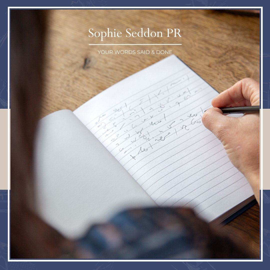 Over the shoulder photo of Sophie Seddon PR writing shorthand notes in a notebook capturing a moment of quiet focus and creative thinking to write her brand manifesto.
